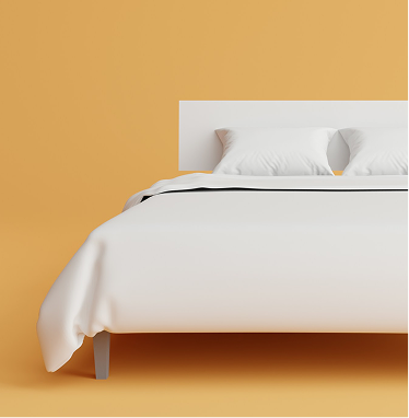 Ein gemütliches weisses Bett vor einer warmen orangefarbenen Wand – so sieht minimalistisches Design im Capsule Hotel aus.