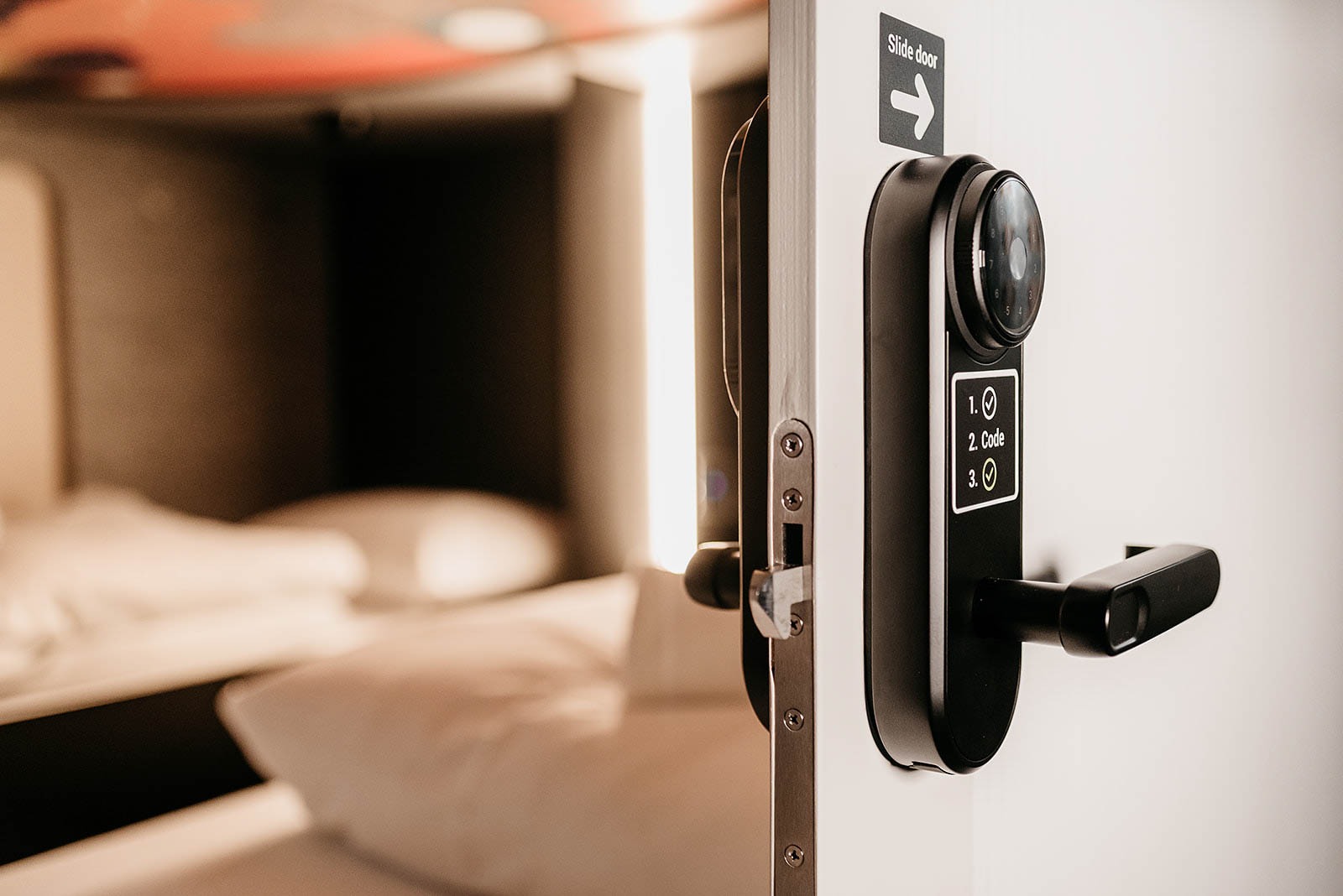 Sliding door with digital lock on a capsule room at Capsule Hotel Lucerne Old Town.