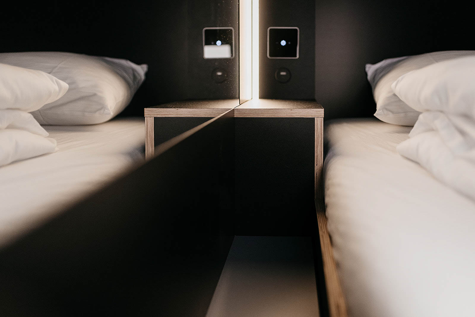 Modern capsule room with ambient lighting and plush bedding at Capsule Hotel Lucerne Old Town.