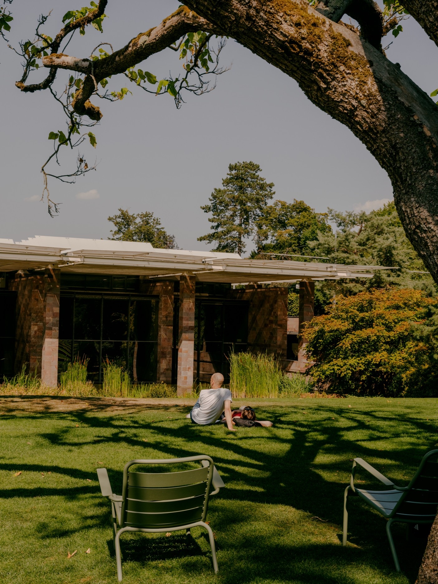 Besucher, die sich auf dem Rasen vor der von Renzo Piano entworfenen Fondation Beyeler in Riehen bei Basel entspannen