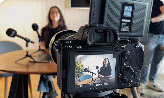Camera capturing a team member during a lively podcast recording at Capsule Hotel.