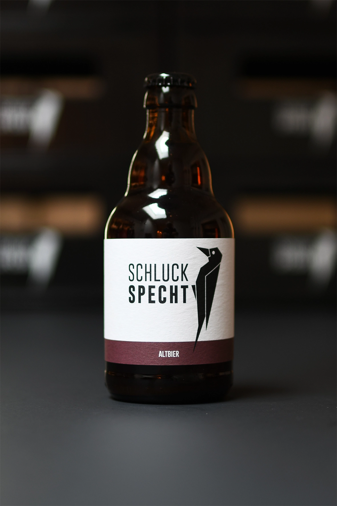 Schluck Specht beer on dark background, showcasing a crafted drink available at Capsule Hotel bars.