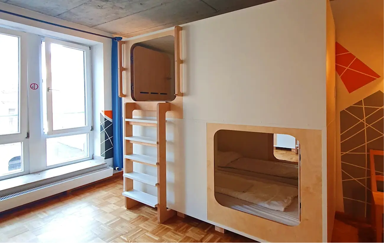 Modern capsule room with wooden bunk design and large windows at Capsule Hotel Europe.