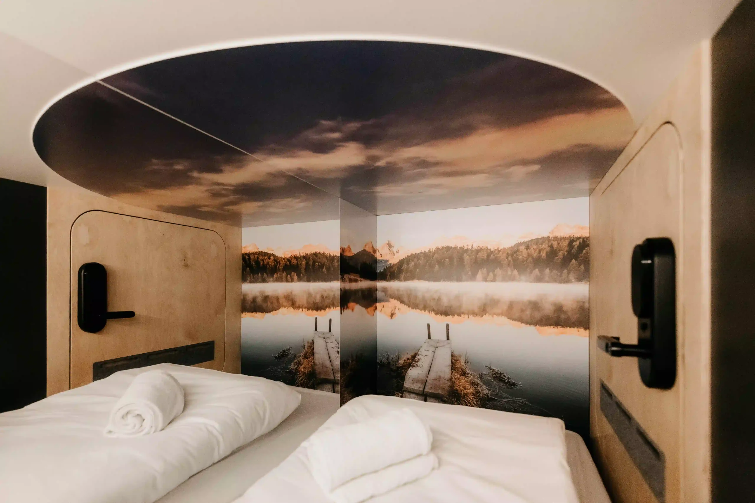 Scenic mural and bedding in capsule room at Capsule Hotel Copenhagen Vesterbro.