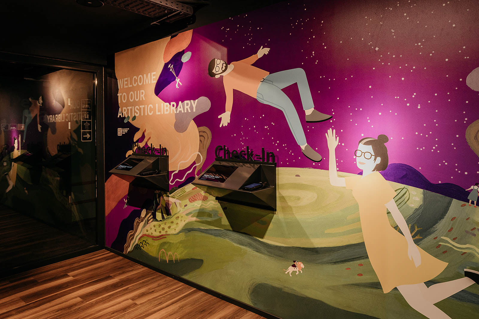 Colorful mural in the artistic library welcome area at Capsule Hotel Lucerne Old Town, featuring playful characters.
