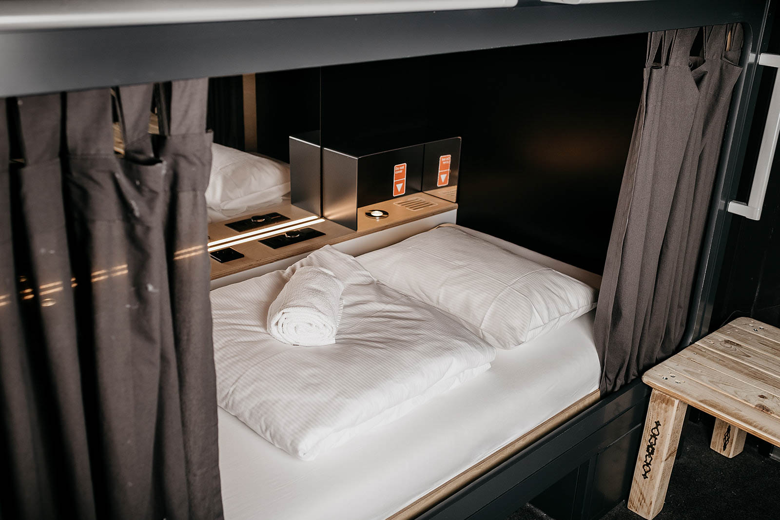 Cozy capsule room with bed and privacy curtain at Capsule Hotel Alpine Garden Zurich Airport.