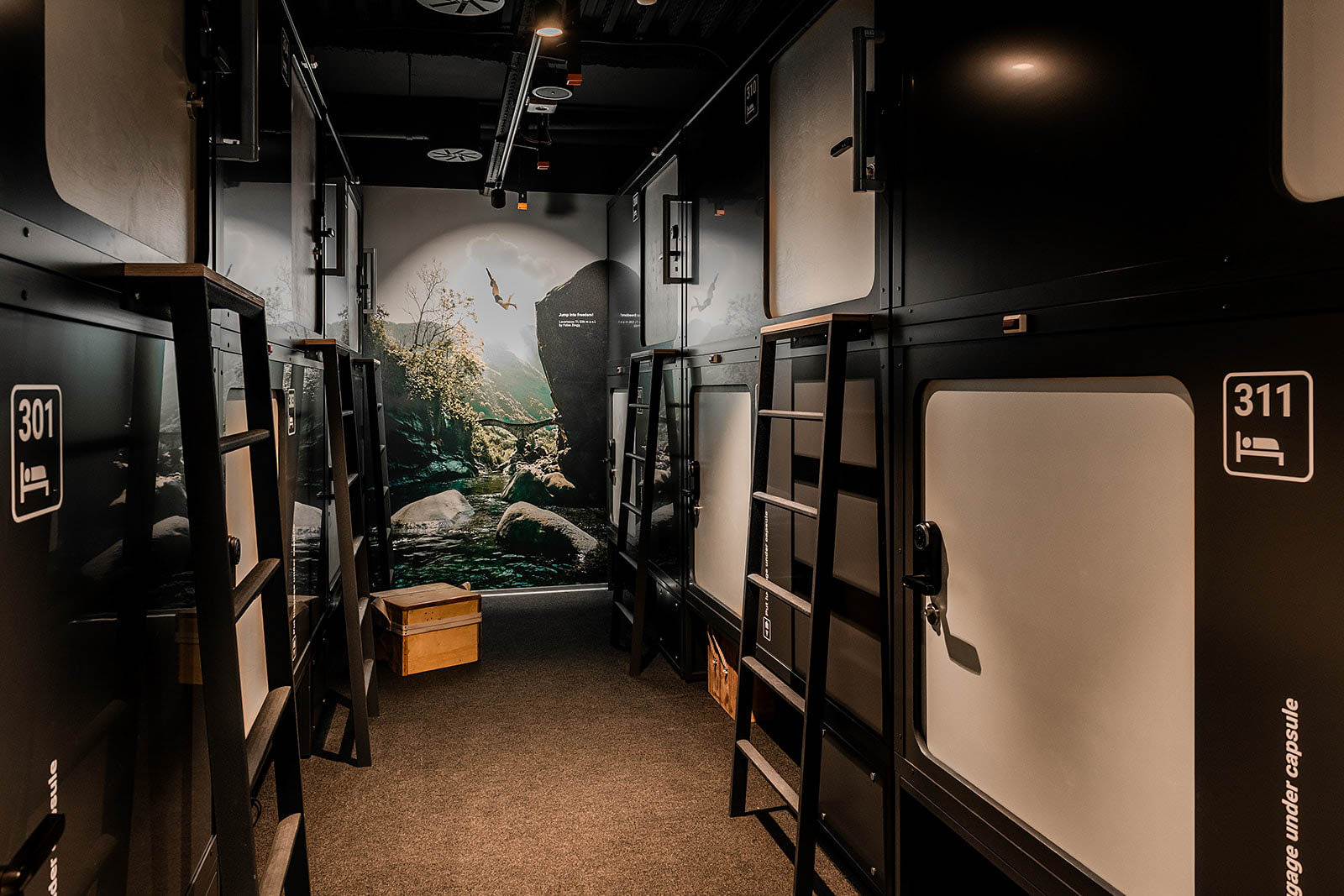 Capsule room hallway with numbered capsule entrances at Capsule Hotel Alpine Garden Zurich Airport.