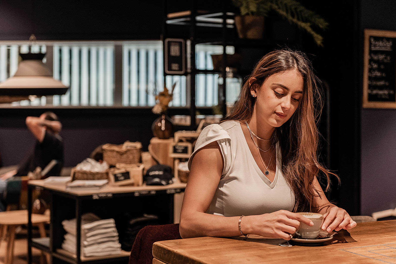 Woman enjoying coffee in lounge area at Capsule Hotel Alpine Garden Zurich Airport.