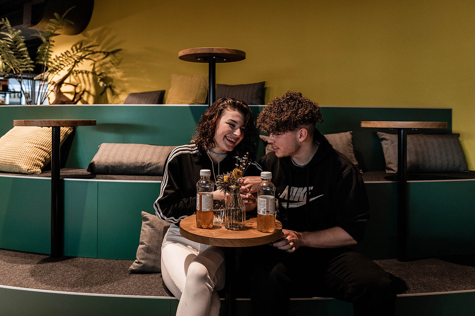 Couple enjoying drinks in stylish lounge area at Capsule Hotel Alpine Garden Zurich Airport.