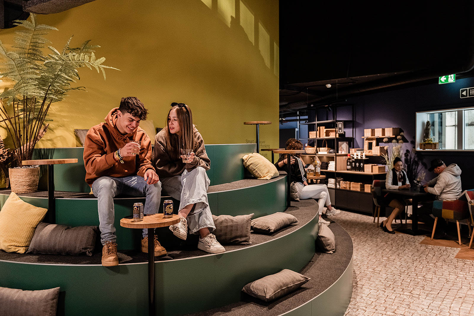 Guests enjoying drinks in the cozy lounge area of Capsule Hotel Alpine Garden Zurich Airport.