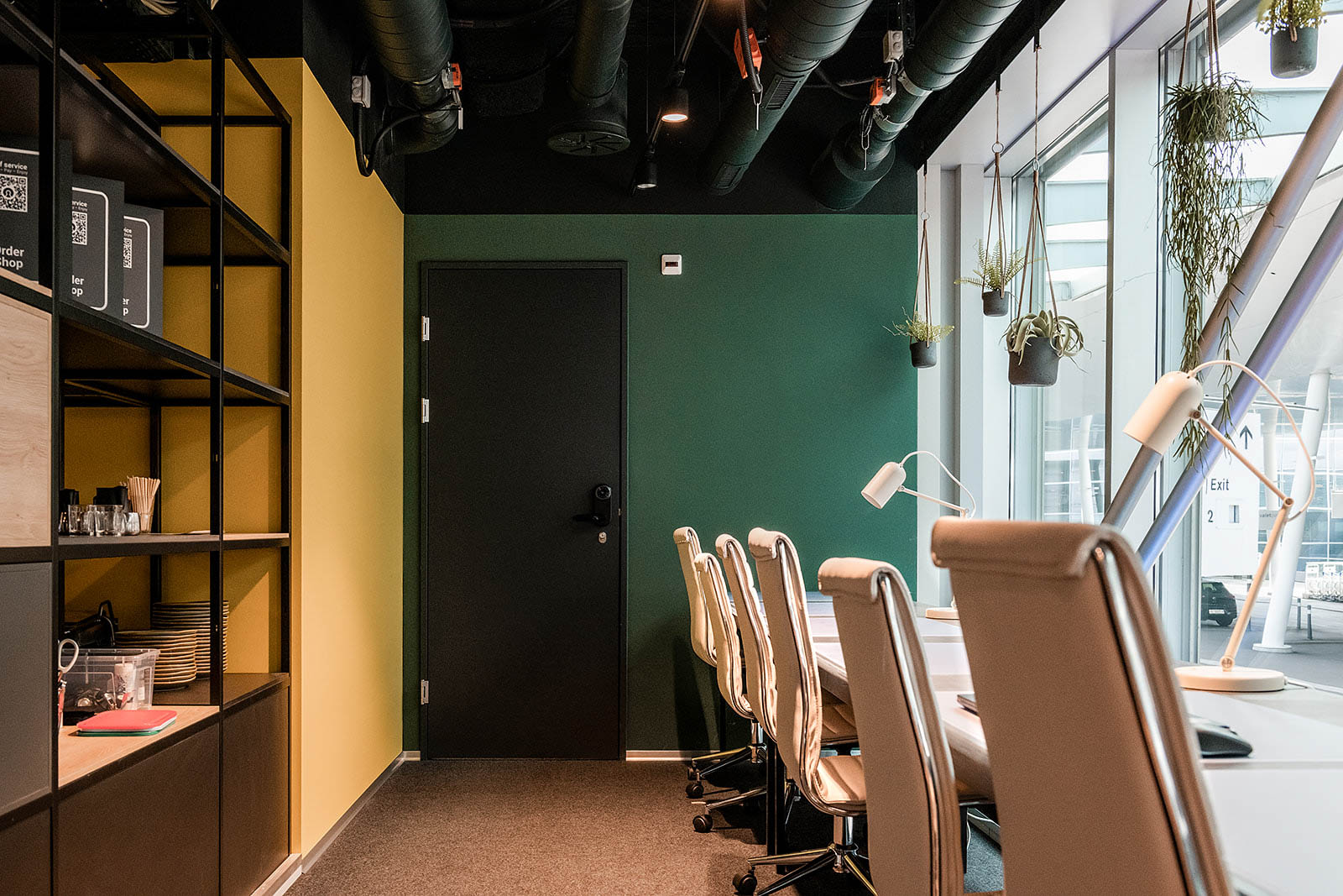 Workspace with modern chairs and hanging plants, Capsule Hotel Alpine Garden Zurich Airport.