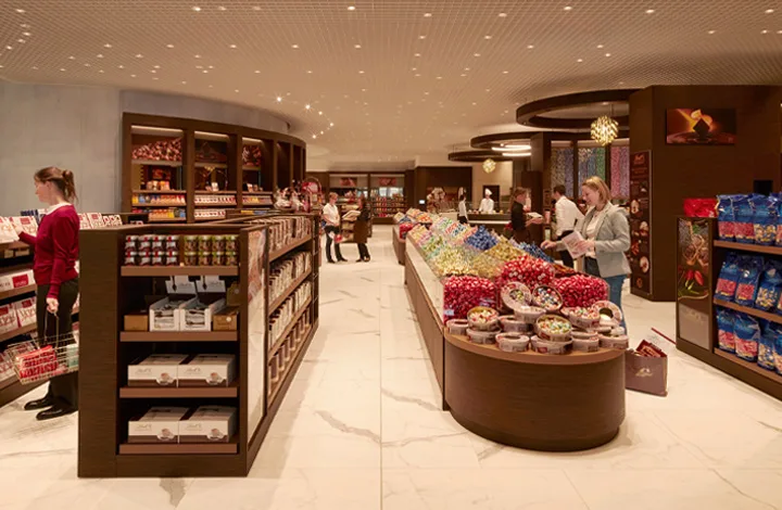 Capsule Hotel retail market with candy and snacks, guests shopping under warm ambient lighting
