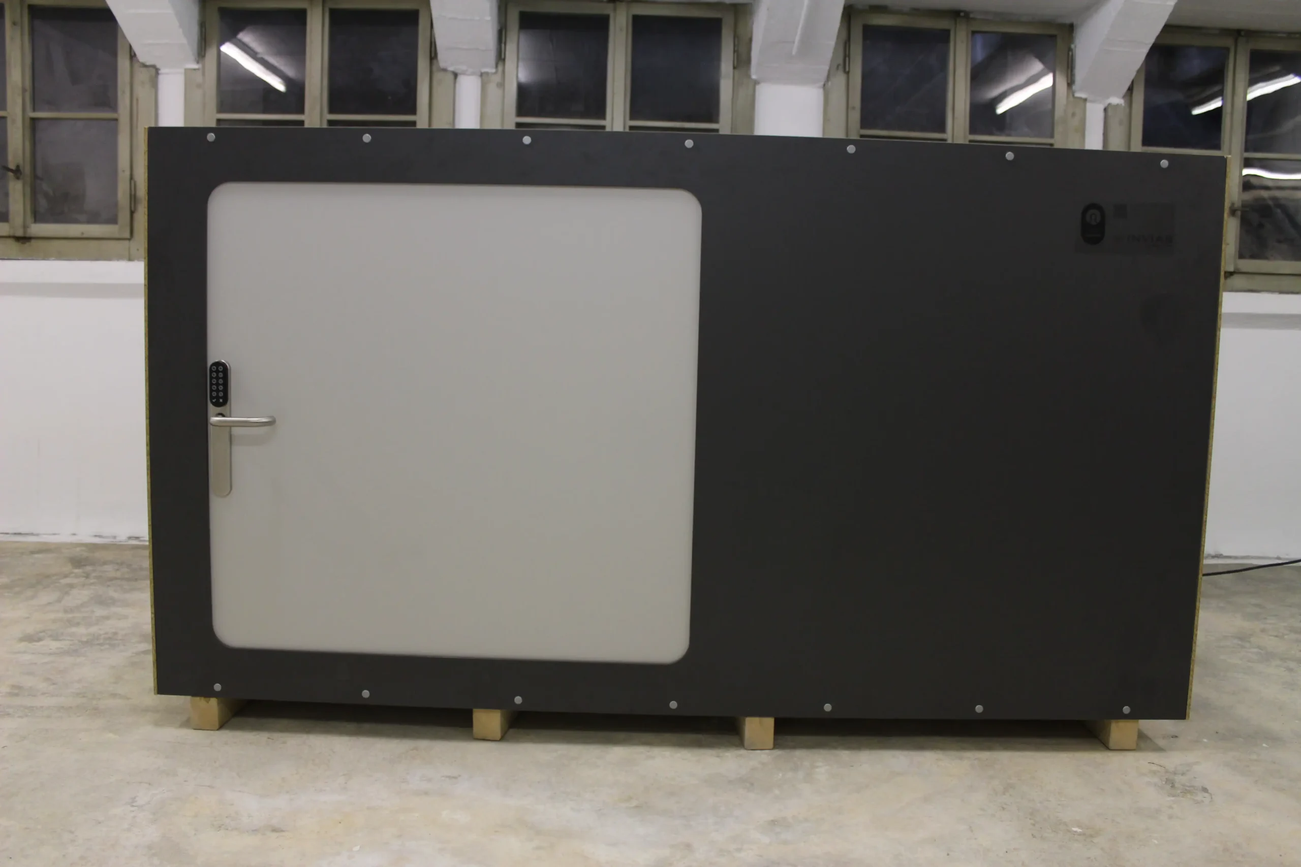 Modern capsule unit with a sleek black and gray design at Capsule Hotel Europe location.