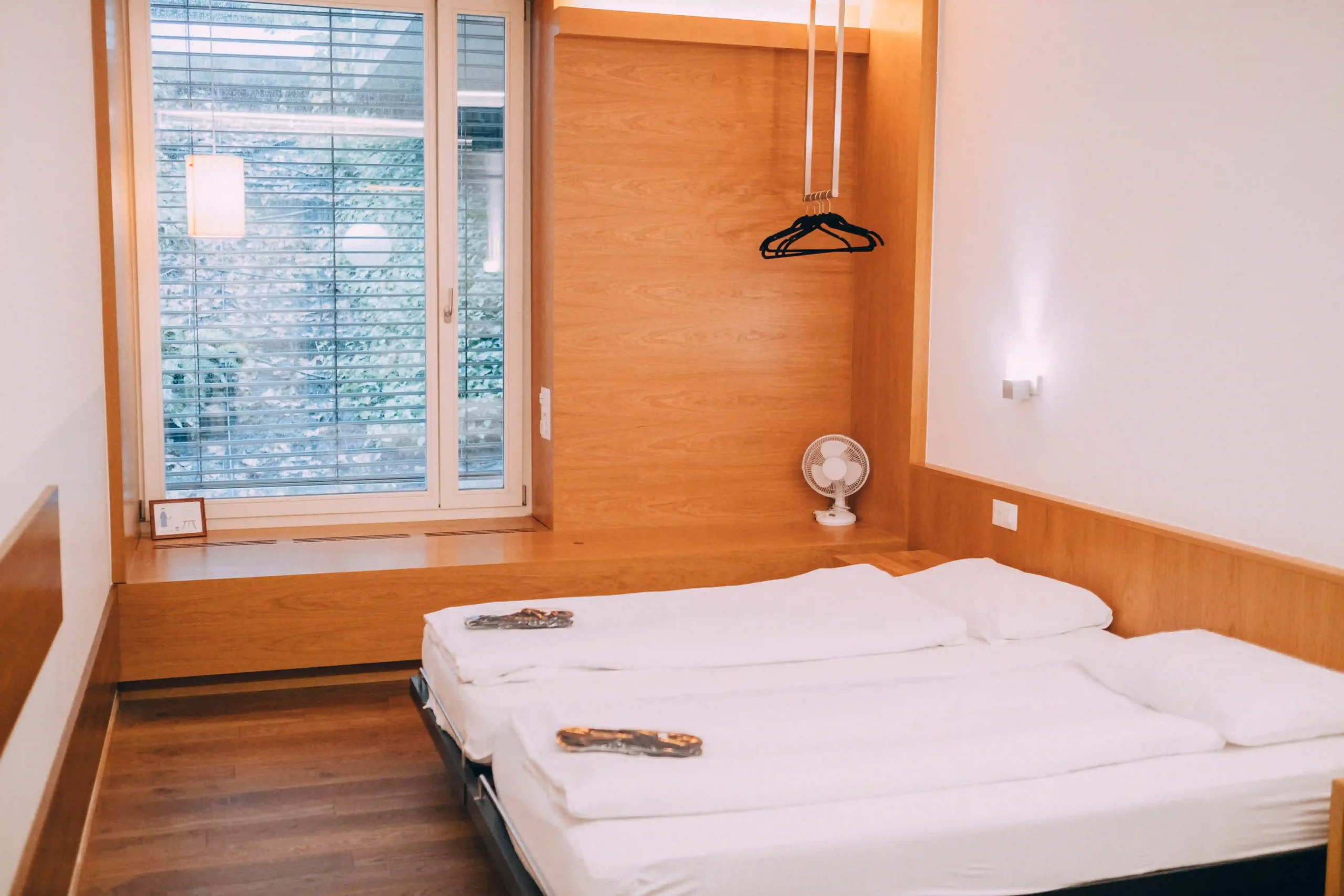 Twin beds in a cozy private apartment with wooden accents at Hyve Basel Capsule Hotel.