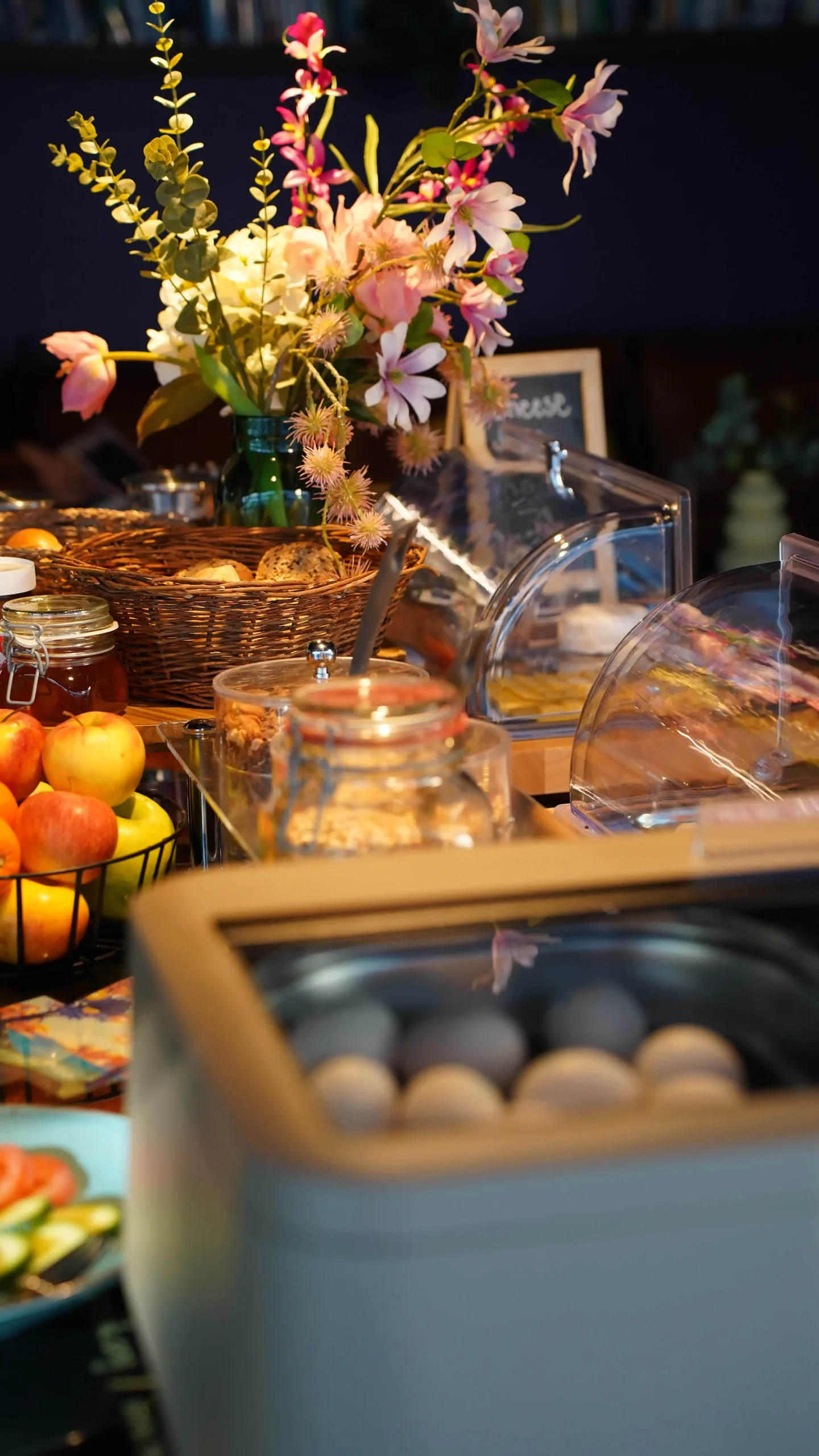 Breakfast spread with fruits, pastries, and flowers at Capsule Hotel Lucerne Old Town.
