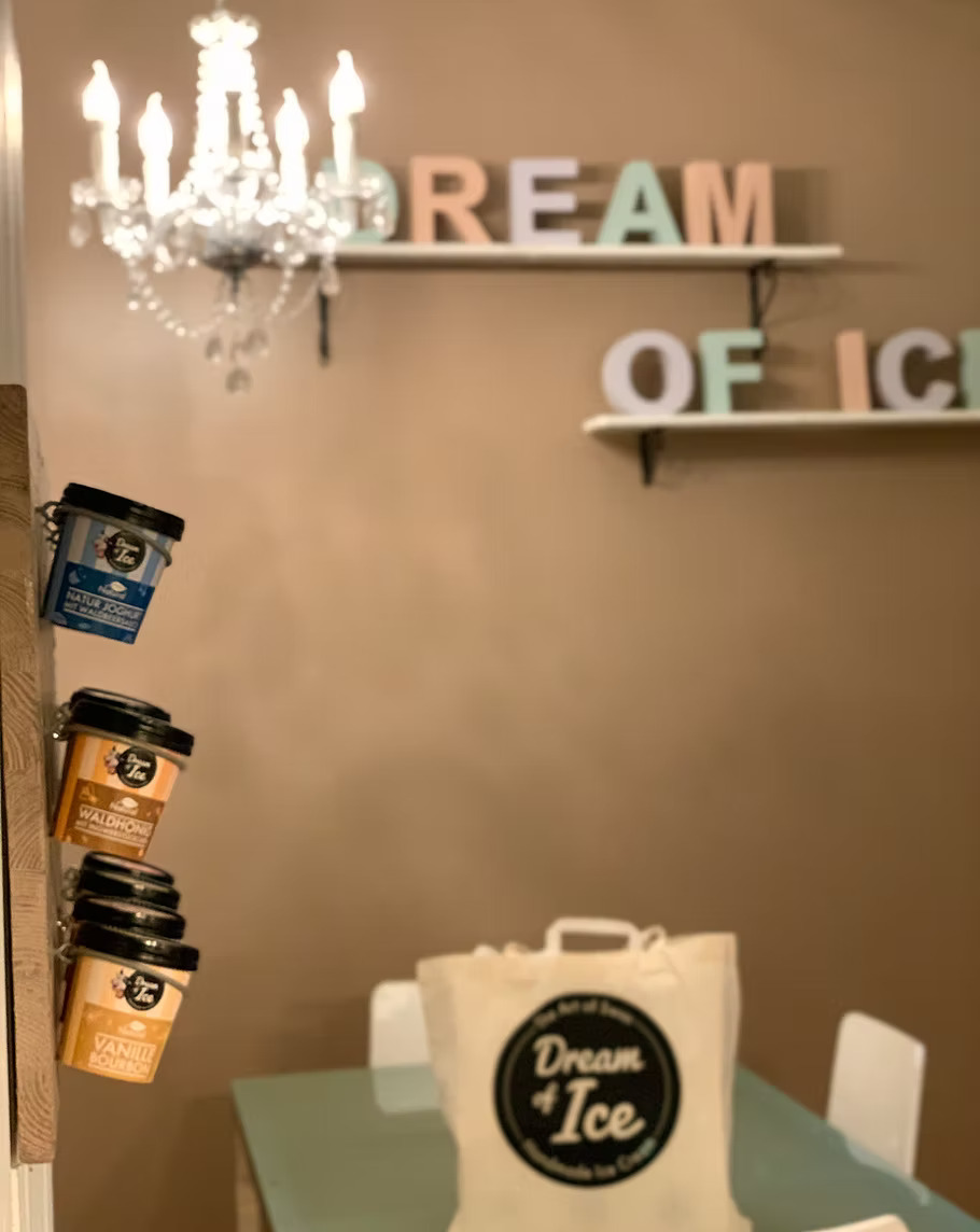 Chic dining area with elegant chandelier, modern decor, and branded ice cream setup at Capsule Hotel, Europe.